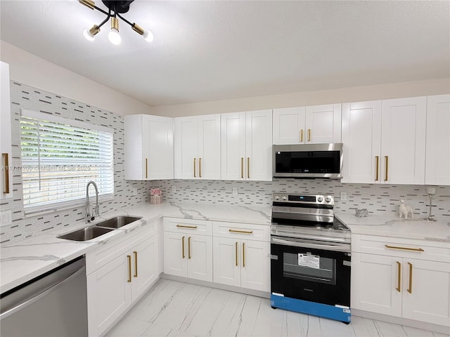 kitchen featuring tasteful backsplash, a sink, marble finish floor, stainless steel appliances, and white cabinetry