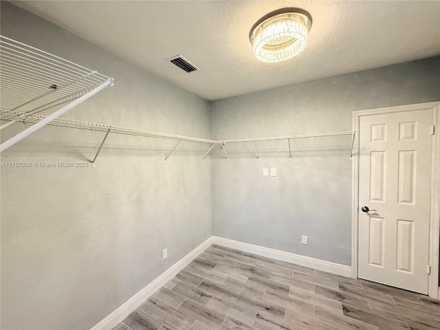 spacious closet featuring wood finished floors and visible vents