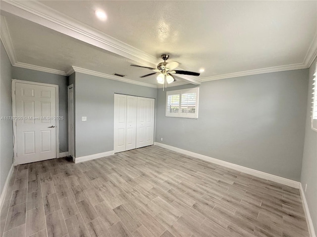 unfurnished bedroom featuring baseboards, crown molding, and light wood-style flooring