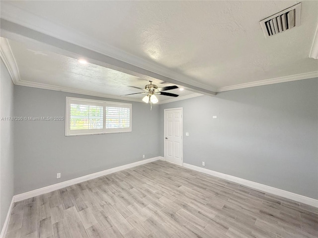 empty room with light wood-style flooring, visible vents, ceiling fan, and crown molding