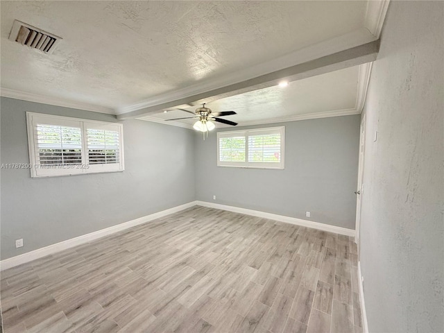 empty room with a textured ceiling, ceiling fan, light wood finished floors, ornamental molding, and visible vents