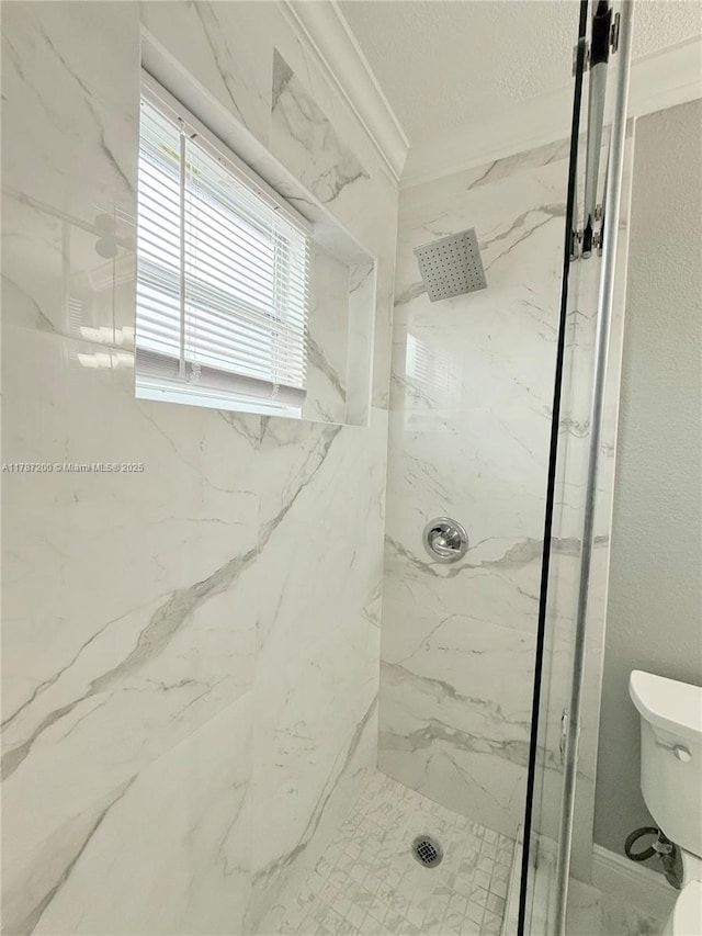 full bathroom featuring crown molding, toilet, and a marble finish shower