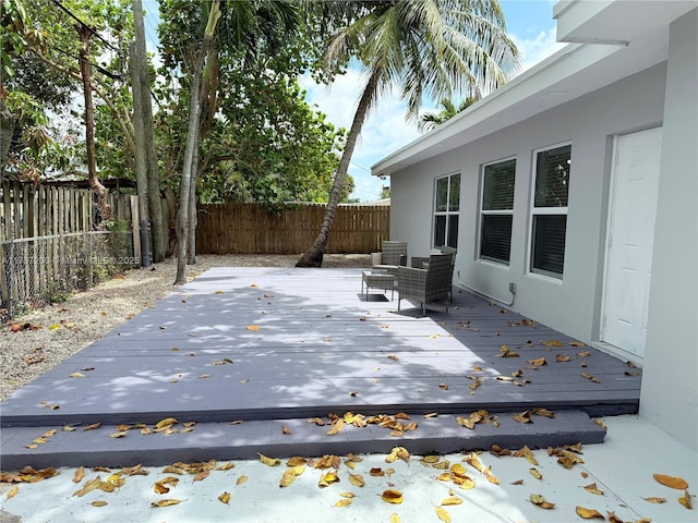 wooden terrace with a fenced backyard