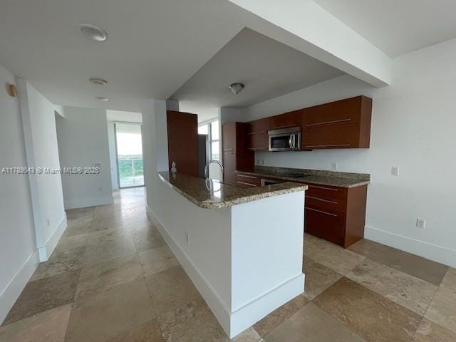 2681 N Flamingo Rd Unit 1501S, Sunrise, FL 33323 - kitchen featuring stainless steel microwave, a peninsula, stone counters, and light stone finish flooring