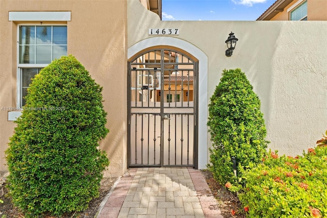 14637 SW 15th St, Pembroke Pines, FL 33027 - view of exterior entry featuring a gate and stucco siding