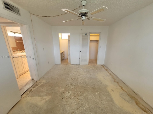 2930 Point E Dr Unit E603, Aventura, FL 33160 - unfurnished bedroom featuring a walk in closet, a textured ceiling, visible vents, and connected bathroom