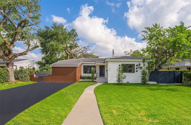 167 NW 100th Ter, Miami Shores, FL 33150 - view of front of house with stucco siding, a tile roof, a front yard, and fence