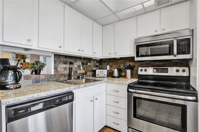 2671 S Course Dr Unit 409, Pompano Beach, FL 33069 - kitchen featuring backsplash, a sink, white cabinetry, and appliances with stainless steel finishes