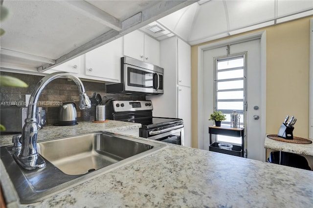 2671 S Course Dr Unit 409, Pompano Beach, FL 33069 - kitchen featuring decorative backsplash, stainless steel appliances, white cabinets, and light countertops