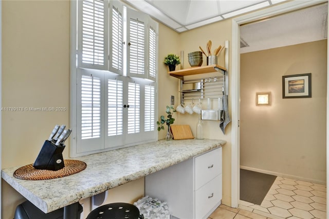 2671 S Course Dr Unit 409, Pompano Beach, FL 33069 - interior space featuring open shelves, light countertops, baseboards, and white cabinetry