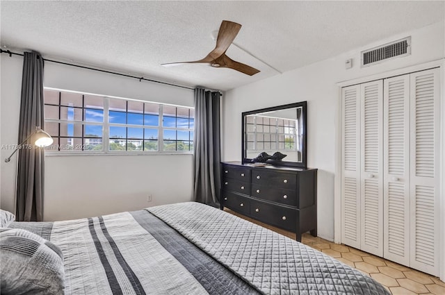 2671 S Course Dr Unit 409, Pompano Beach, FL 33069 - tiled bedroom with a textured ceiling, ceiling fan, visible vents, and multiple windows