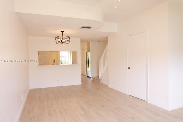 16686 Hemingway Dr Unit 16686, Weston, FL 33326 - empty room with light wood finished floors, baseboards, visible vents, a chandelier, and stairway