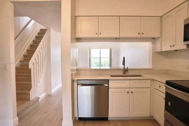 16686 Hemingway Dr Unit 16686, Weston, FL 33326 - kitchen featuring a sink, stainless steel appliances, light wood finished floors, light countertops, and white cabinets