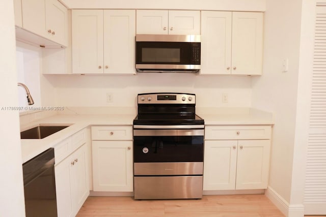 16686 Hemingway Dr Unit 16686, Weston, FL 33326 - kitchen featuring a sink, light wood finished floors, light countertops, white cabinets, and appliances with stainless steel finishes