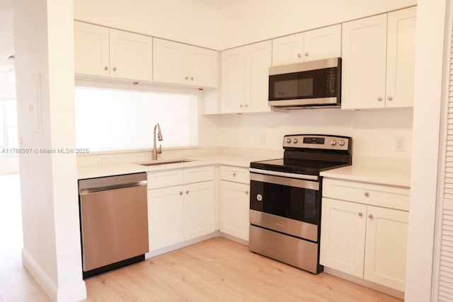 16686 Hemingway Dr Unit 16686, Weston, FL 33326 - kitchen with light countertops, a sink, light wood-type flooring, appliances with stainless steel finishes, and white cabinetry