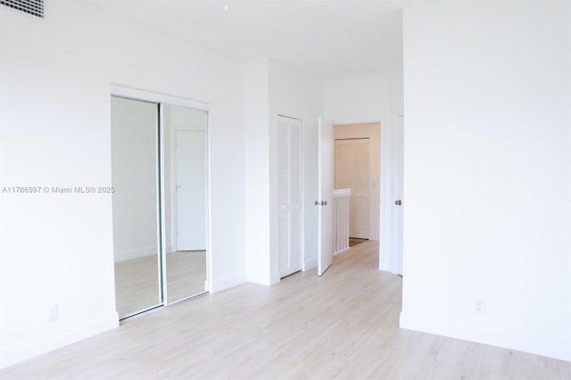 16686 Hemingway Dr Unit 16686, Weston, FL 33326 - unfurnished bedroom featuring light wood-style floors, visible vents, baseboards, and multiple closets