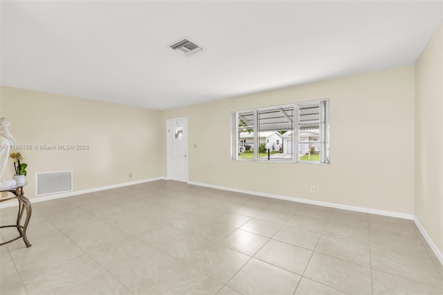 unfurnished room with baseboards, visible vents, and light tile patterned flooring