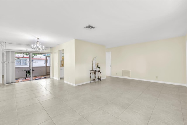 spare room featuring baseboards, visible vents, a notable chandelier, and light tile patterned floors