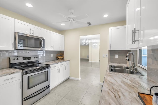 kitchen featuring ceiling fan, white cabinetry, stainless steel appliances, and a sink