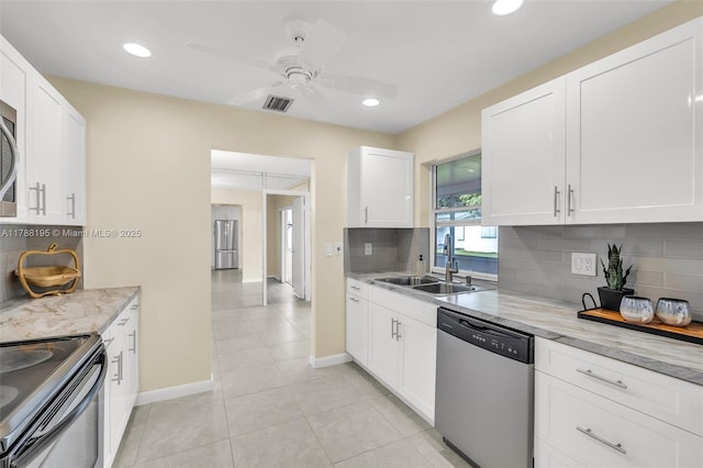kitchen featuring tasteful backsplash, a sink, stainless steel appliances, white cabinetry, and visible vents
