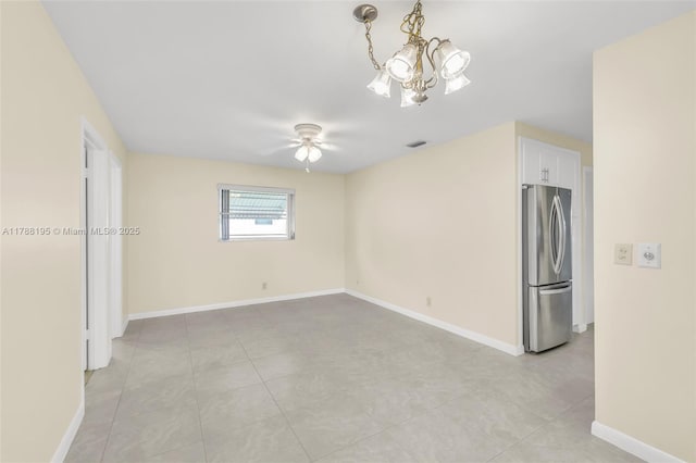 unfurnished room with ceiling fan with notable chandelier, baseboards, and visible vents