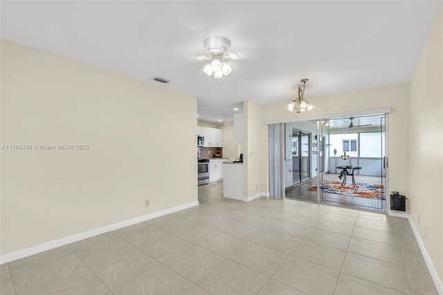 spare room with visible vents, light tile patterned floors, french doors, baseboards, and ceiling fan with notable chandelier