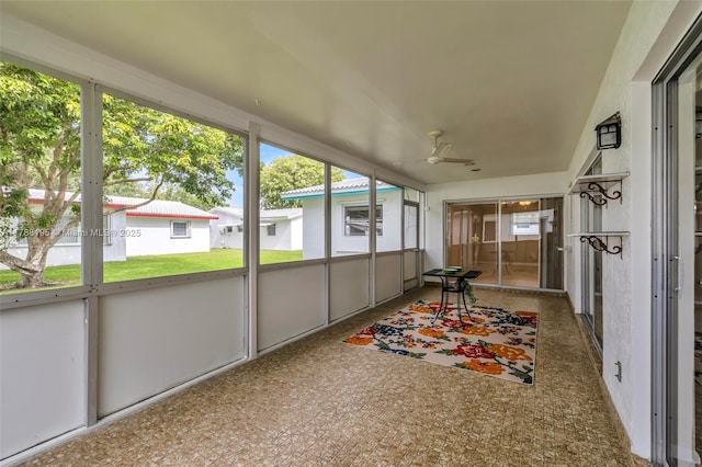 unfurnished sunroom featuring ceiling fan