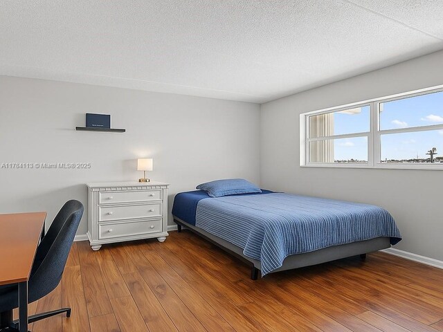 4500 N Flagler Dr Unit C24, West Palm Beach, FL 33407 - bedroom with wood finished floors, baseboards, and a textured ceiling