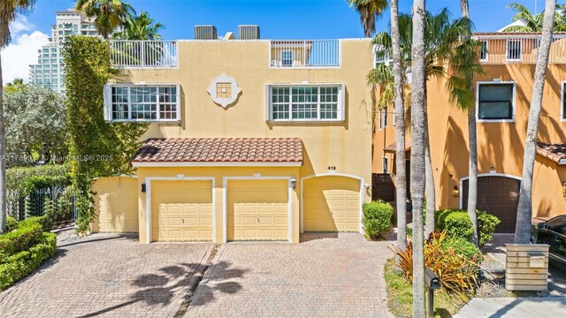 419 SW 5th St Unit 419, Fort Lauderdale, FL 33315 - townhome / multi-family property featuring stucco siding, a tiled roof, a garage, and driveway