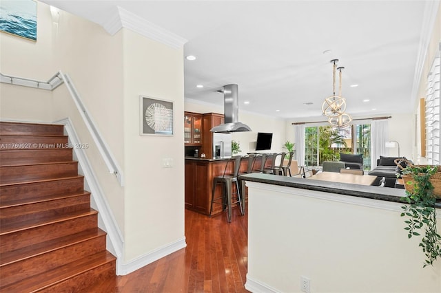 kitchen featuring recessed lighting, a kitchen breakfast bar, island range hood, open floor plan, and dark wood-style flooring
