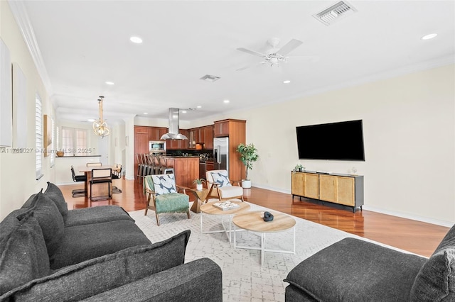 living room featuring recessed lighting, crown molding, and light wood-style flooring