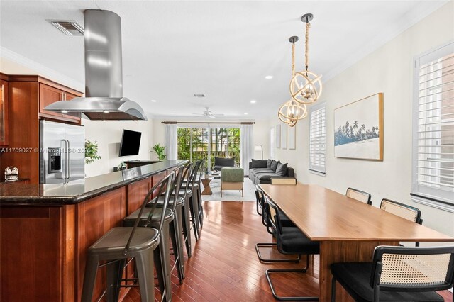 419 SW 5th St Unit 419, Fort Lauderdale, FL 33315 - kitchen featuring stainless steel fridge, a kitchen bar, dark wood finished floors, open floor plan, and range hood