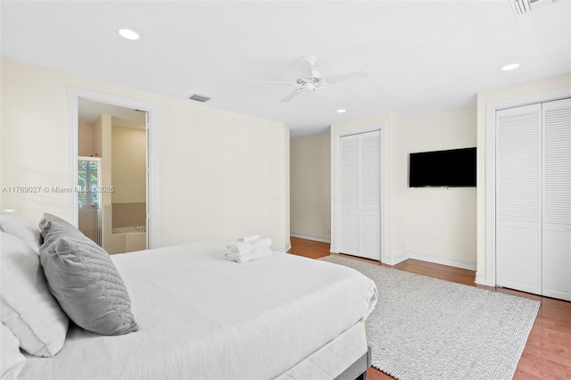 bedroom featuring wood finished floors, multiple closets, visible vents, and recessed lighting