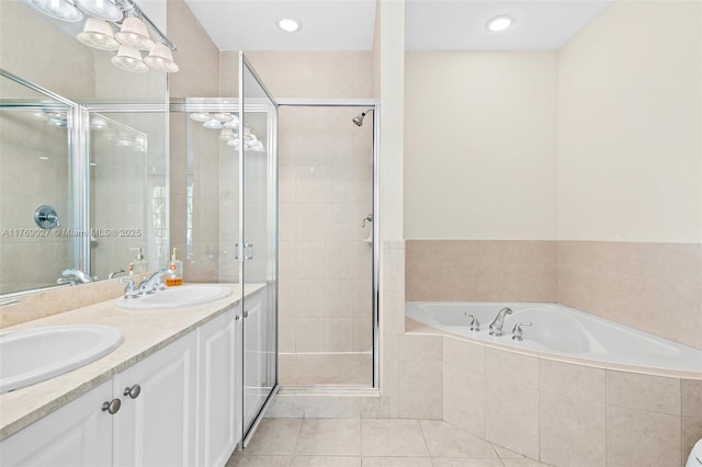 bathroom with a bath, tile patterned floors, a stall shower, and a sink