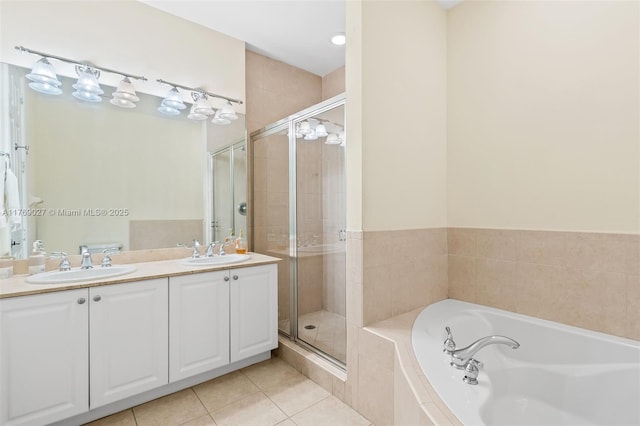 full bathroom featuring a garden tub, a stall shower, and a sink