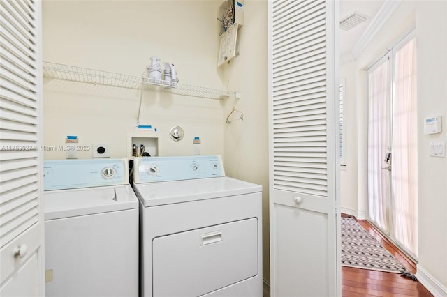 washroom featuring laundry area, dark wood finished floors, baseboards, washing machine and dryer, and visible vents
