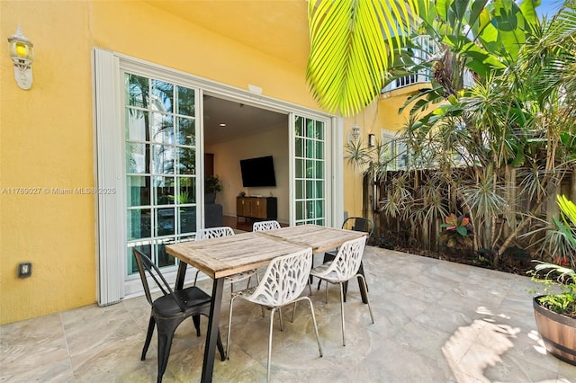 view of patio featuring outdoor dining area and fence