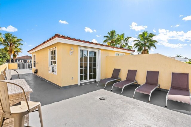 419 SW 5th St Unit 419, Fort Lauderdale, FL 33315 - rear view of property featuring stucco siding, a patio, cooling unit, and a tiled roof
