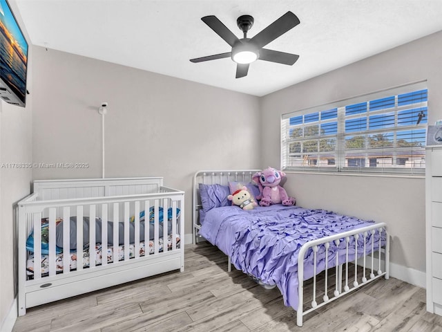 bedroom with wood finished floors, baseboards, and ceiling fan