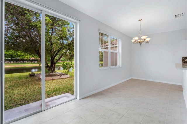 unfurnished dining area with baseboards, a chandelier, visible vents, and a water view