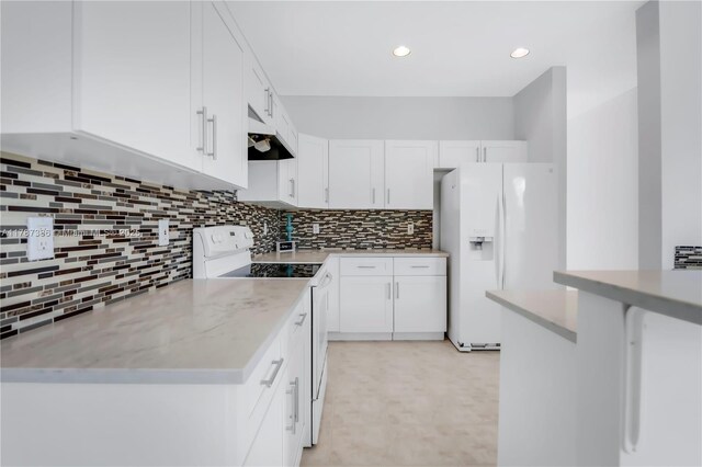 kitchen with white appliances, light floors, decorative backsplash, under cabinet range hood, and white cabinets