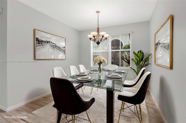 dining space with a chandelier, wood finished floors, and baseboards