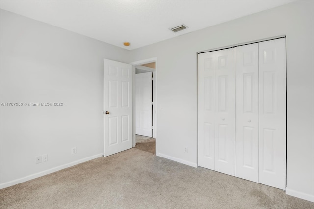 unfurnished bedroom with baseboards, carpet flooring, visible vents, and a closet