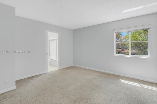 unfurnished room featuring carpet floors, a textured ceiling, and baseboards