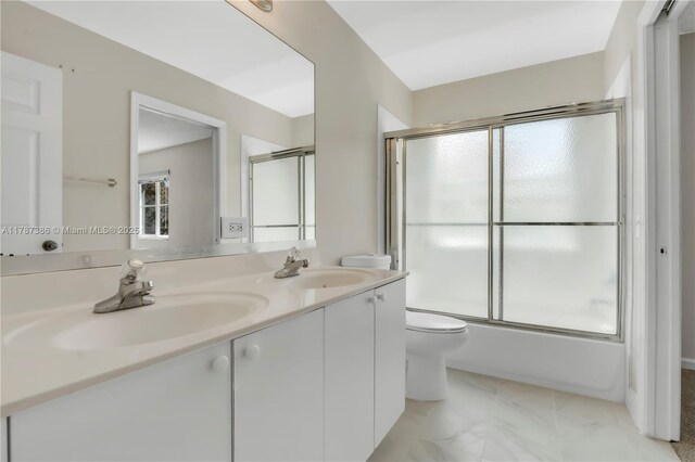 bathroom with double vanity, a sink, and a healthy amount of sunlight