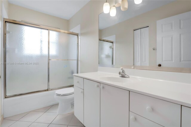 full bathroom with toilet, tile patterned flooring, vanity, and combined bath / shower with glass door