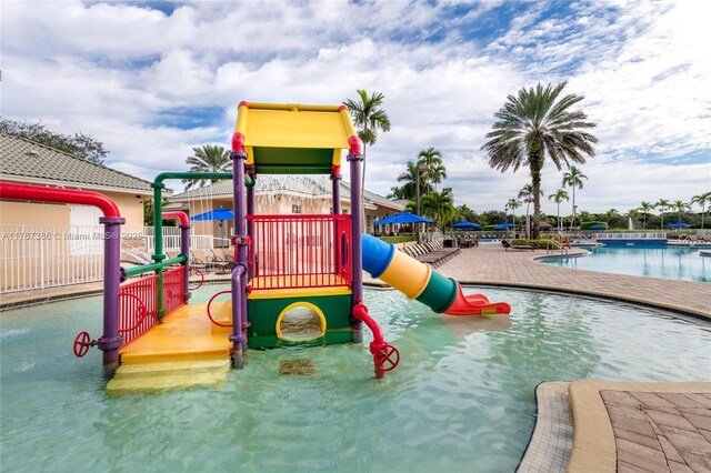 communal playground with fence, a community pool, and a water play area