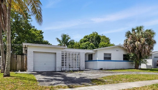 4210 NW 23rd St, Lauderhill, FL 33313 - ranch-style house with a garage, fence, and aphalt driveway