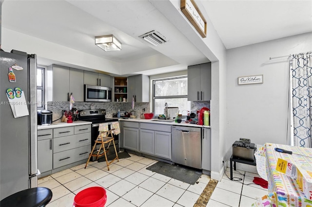 4210 NW 23rd St, Lauderhill, FL 33313 - kitchen with backsplash, appliances with stainless steel finishes, a sink, and gray cabinetry