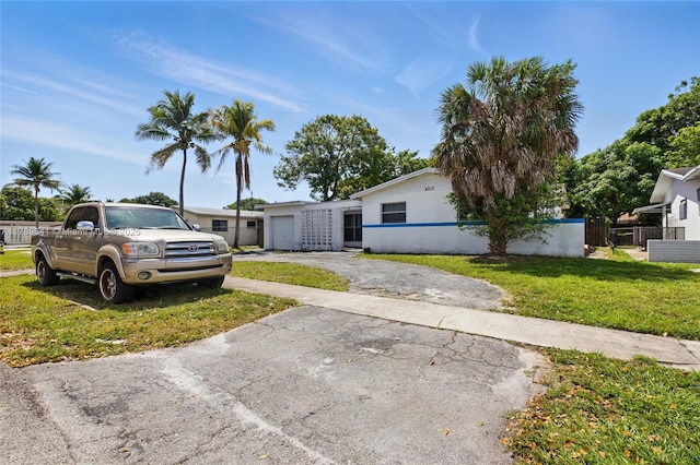 4210 NW 23rd St, Lauderhill, FL 33313 - view of front of property featuring fence, a front lawn, and aphalt driveway
